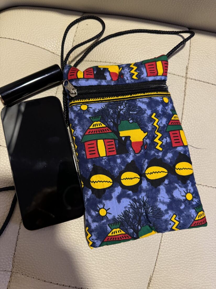 The Ankara crossbody purse, sized against a phone.