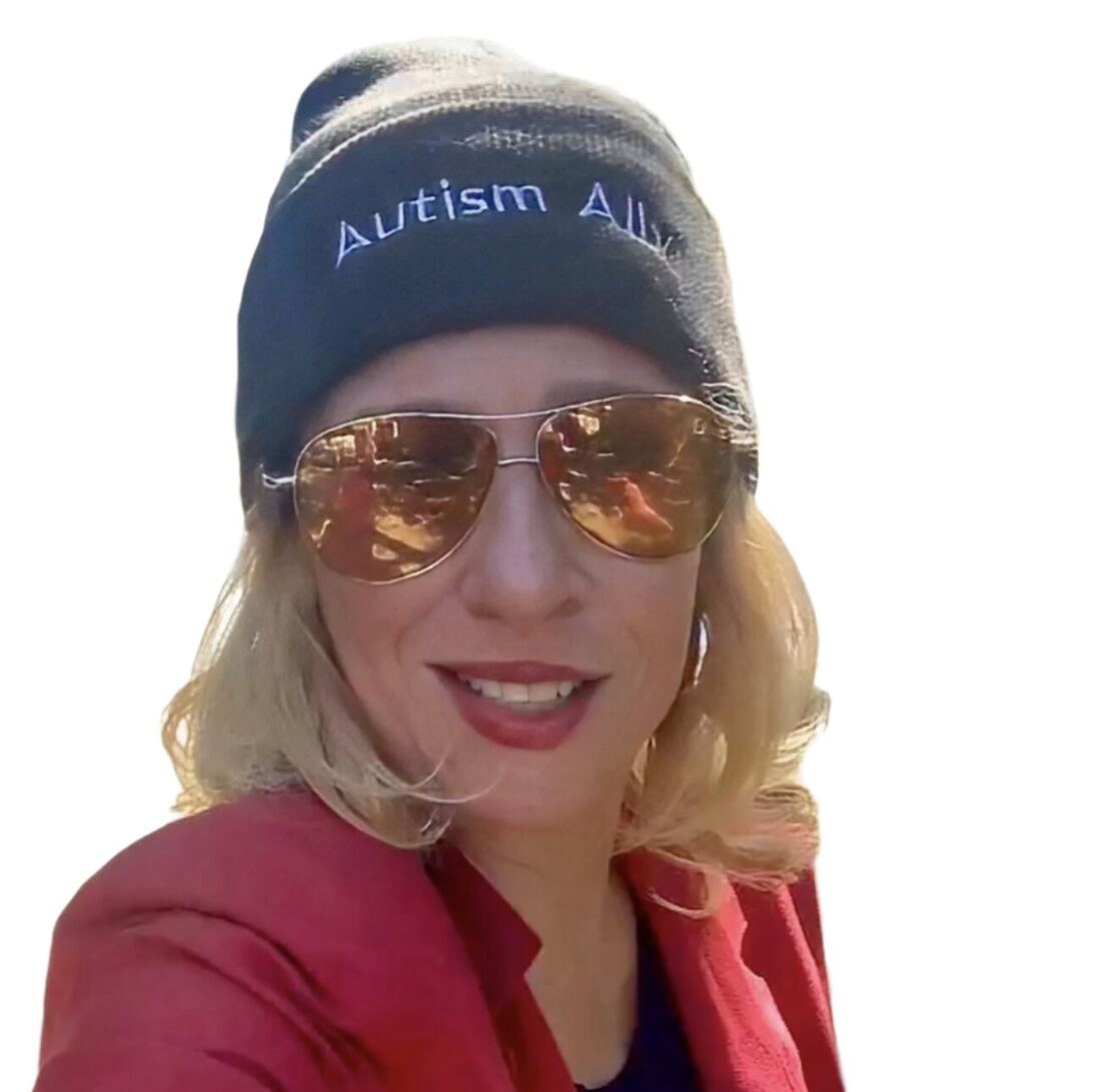 A woman in a navy Autism Ally beanie and aviator sunglasses.