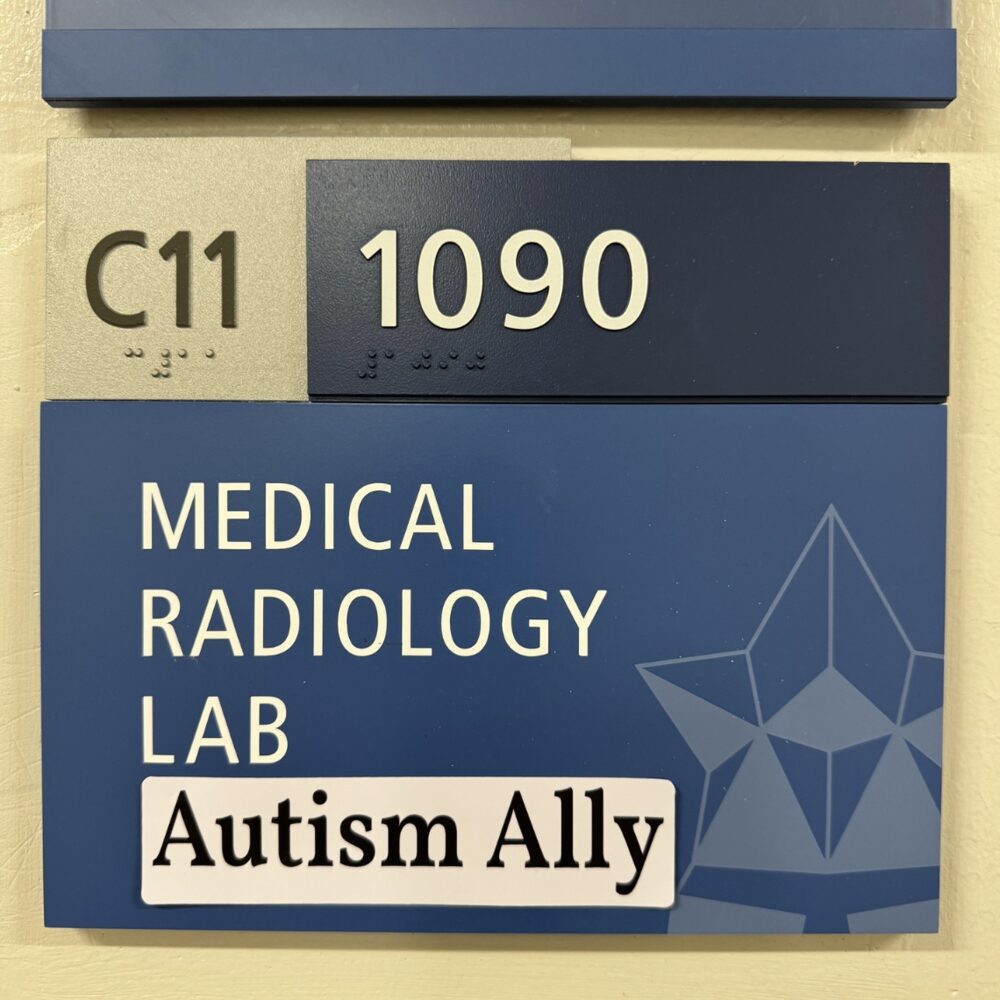 The Autism Ally sticker on the door sign of a medical radiology lab.