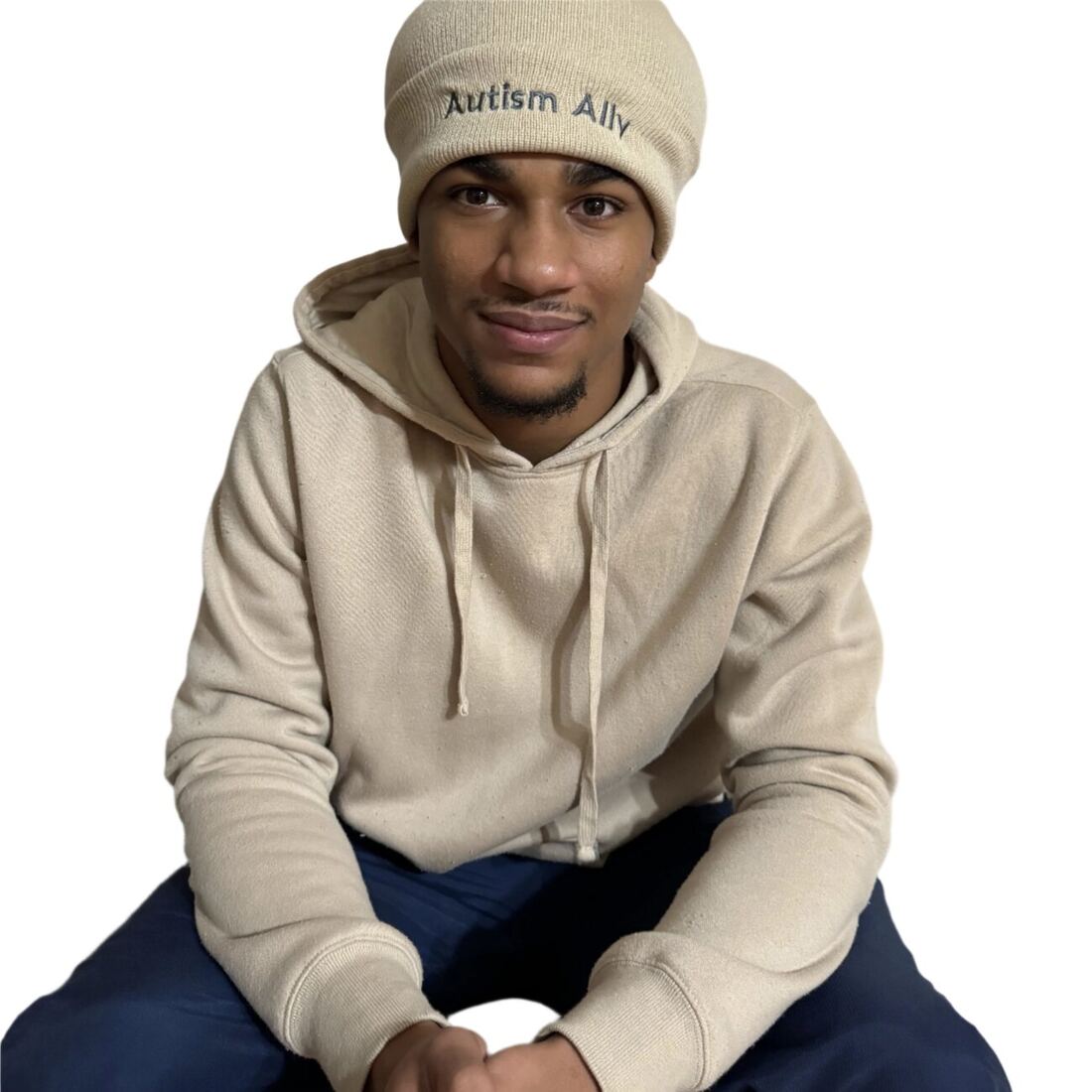 A young man wearing the cream Autism Ally beanie.